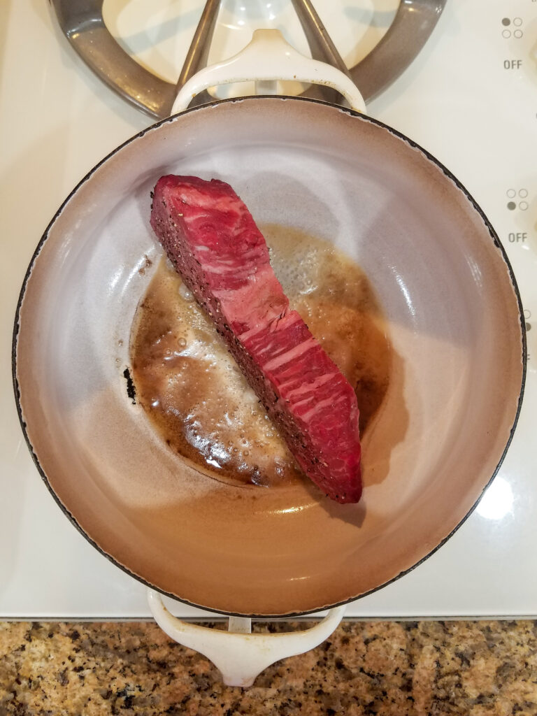 Pan searing the steak.