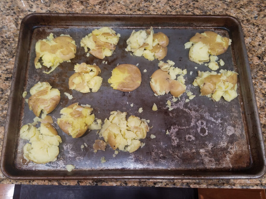 Smashed potatoes on a baking sheet. 