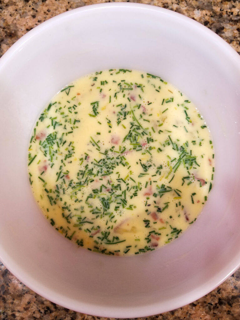Loaded potato quiche ingredients mixed together in a bowl