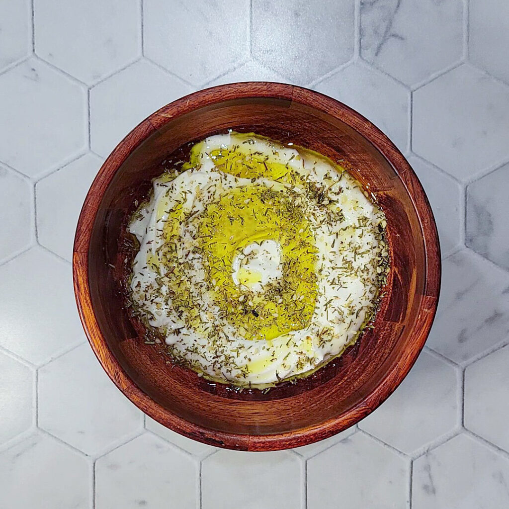 A bowl full of labneh with olive oil and za'atar.