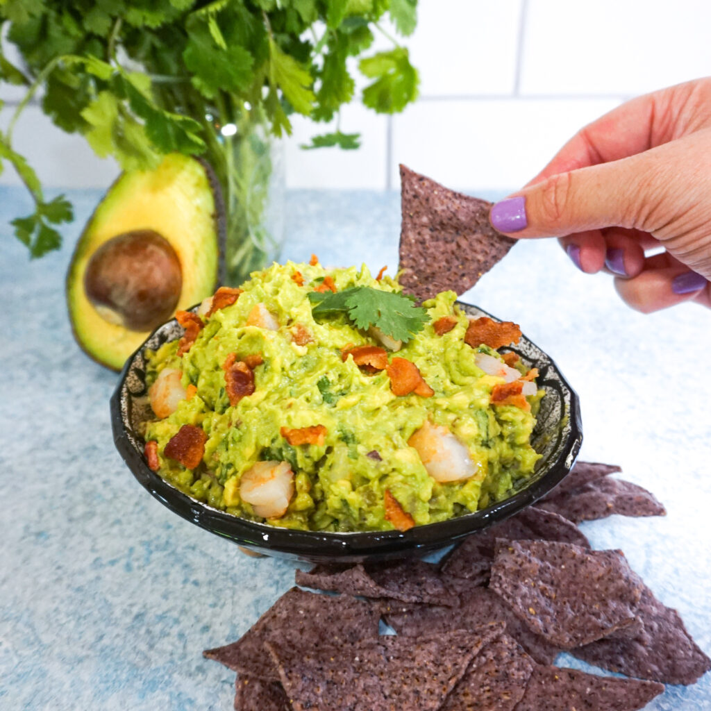 Dipping a chip in to the loaded bacon shrimp guacamole