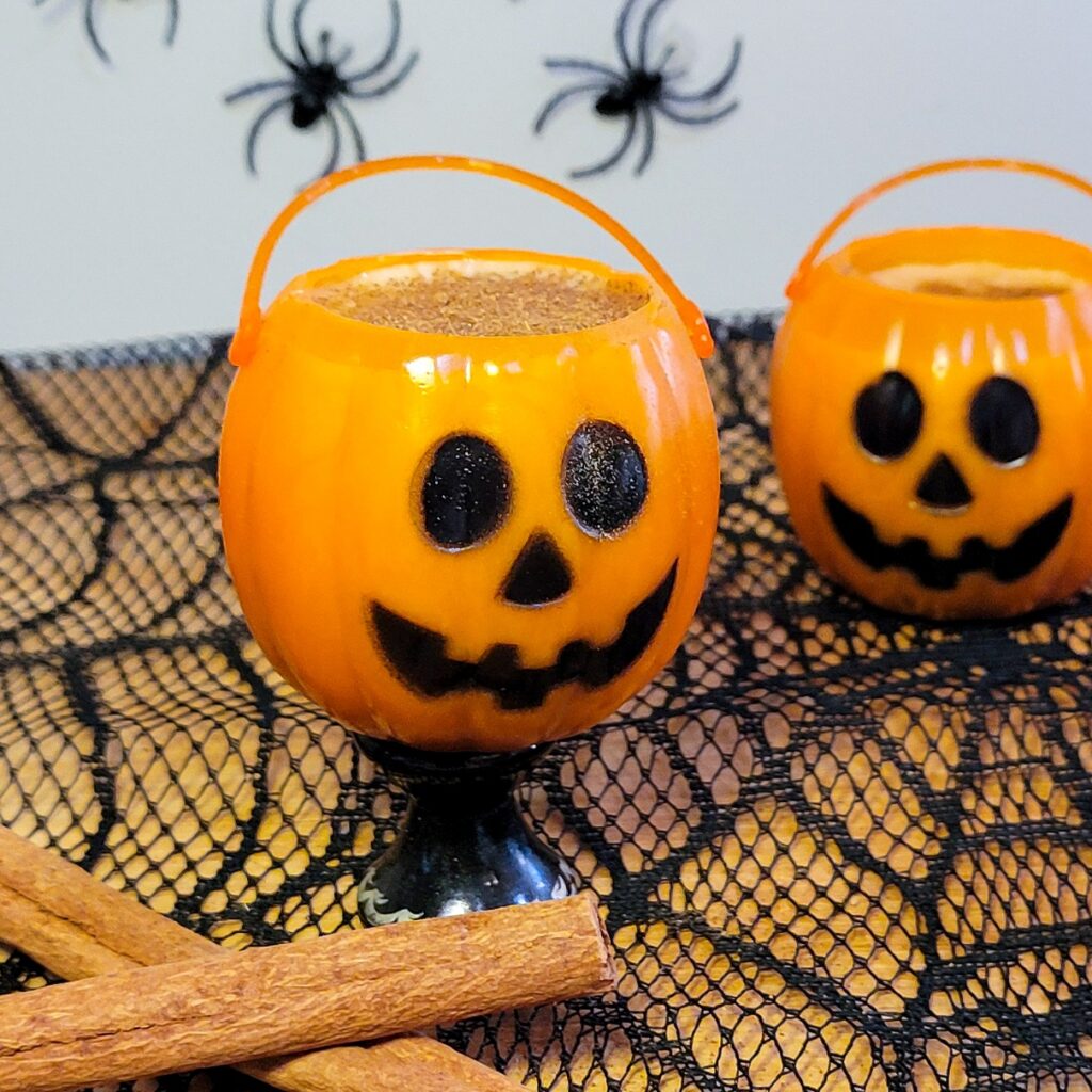 A pumpkin spiced latte Halloween shooters inside a jack-o-lantern shot glasses.