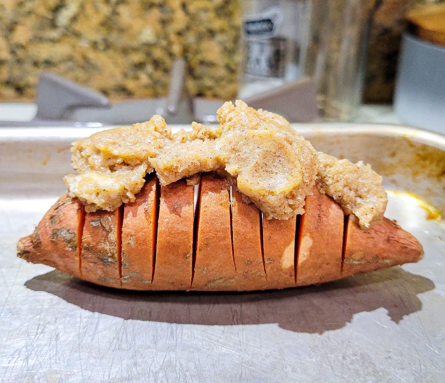 Compound butter mounded on top of a hasselback sliced sweet potato.