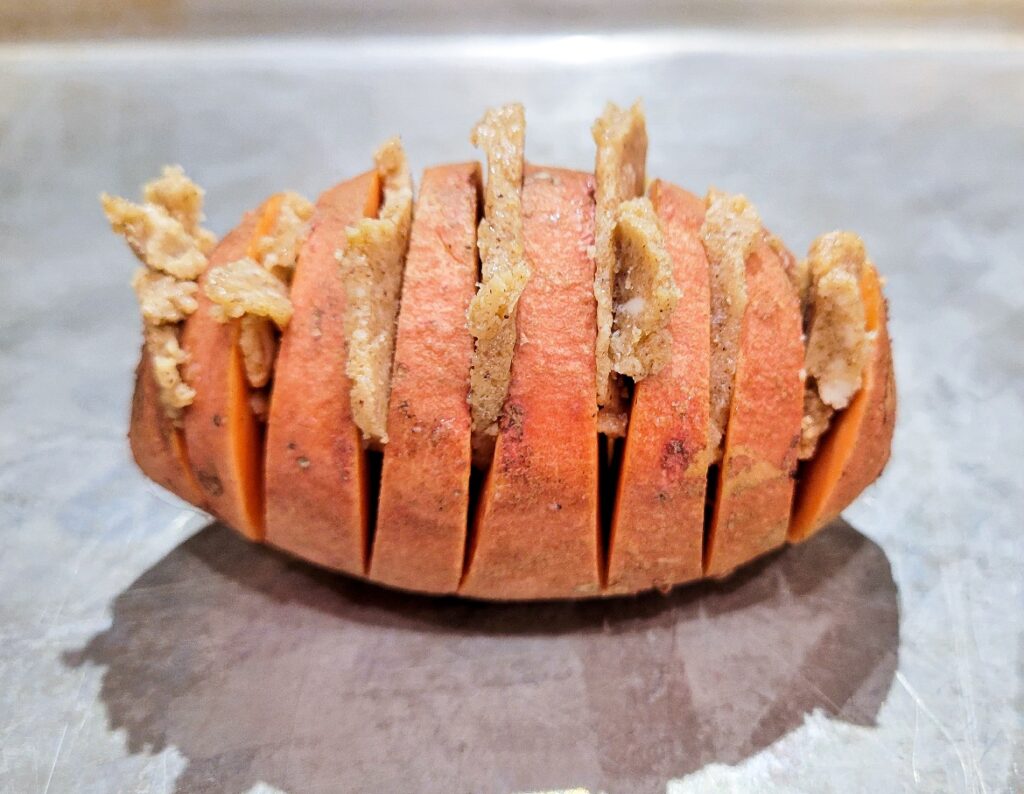 Sliced compound butter stuffed into the sliced hasselback sweet potato. 
