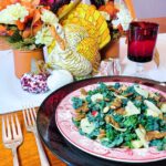 A table setting with a plate full of candied pumpkin seed kale salad.